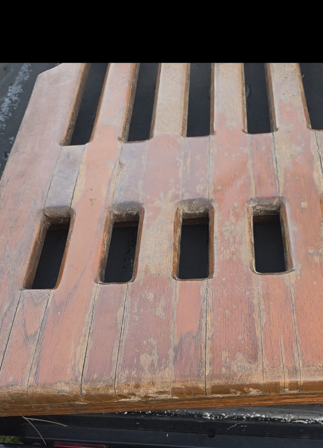 Before teak restoration: close view of a slotted panel with a worn, uneven surface